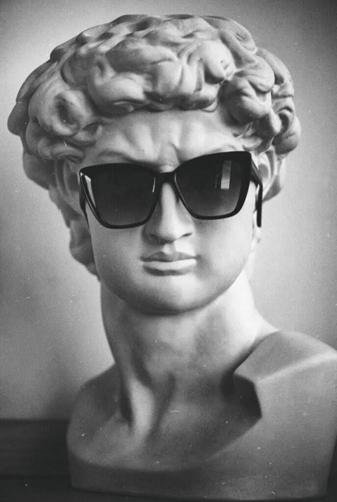 a black and white photo of a bust of a man wearing sunglasses